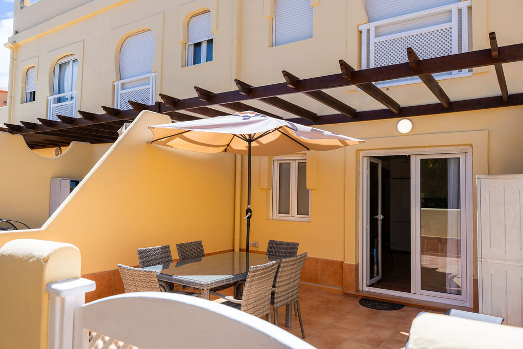 Terraza privada con acceso directo a la piscina en Apartamentos y Villas El Sultán.